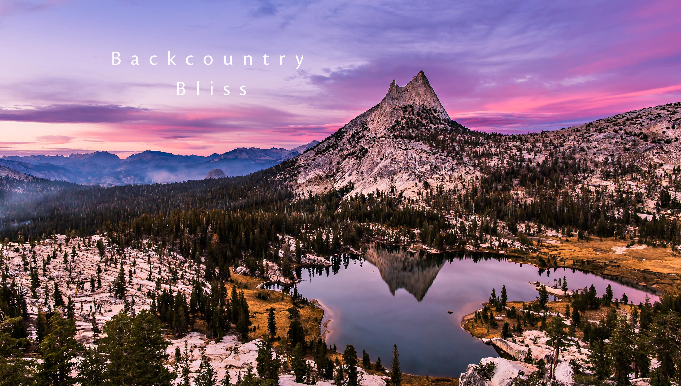 Cathedral Lake and Peak with pink purple clouds at sunset.