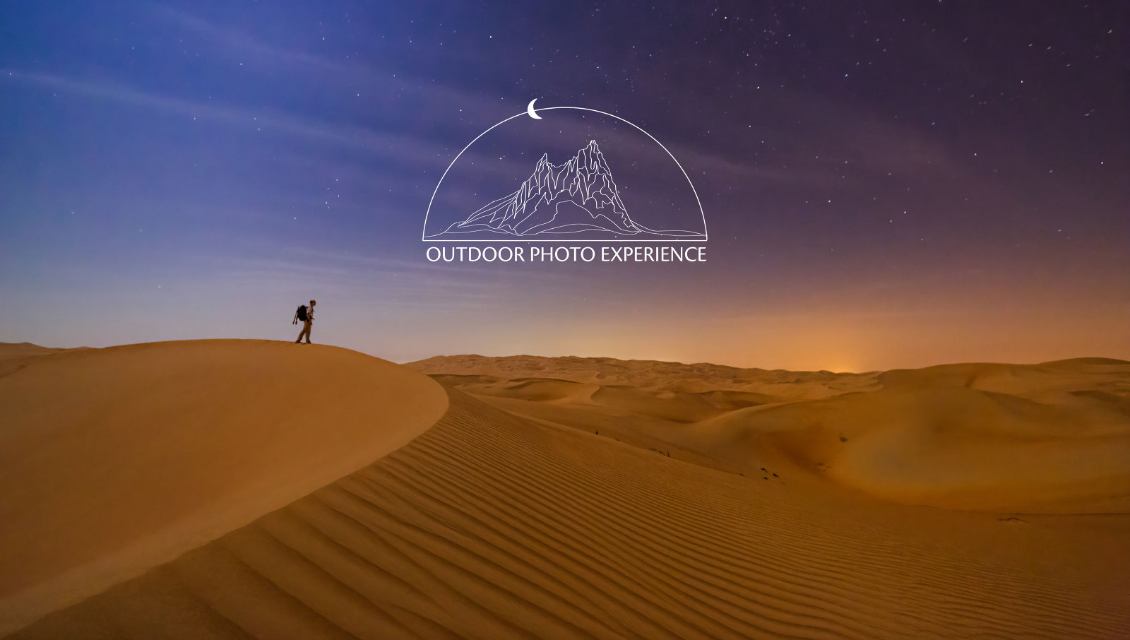 Photographer with pack and tripod standing on a sand dune under the stars in Death Valley