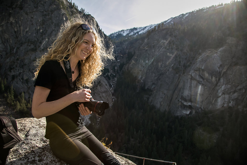 Woman photographer smiling in Yosemite with camera.