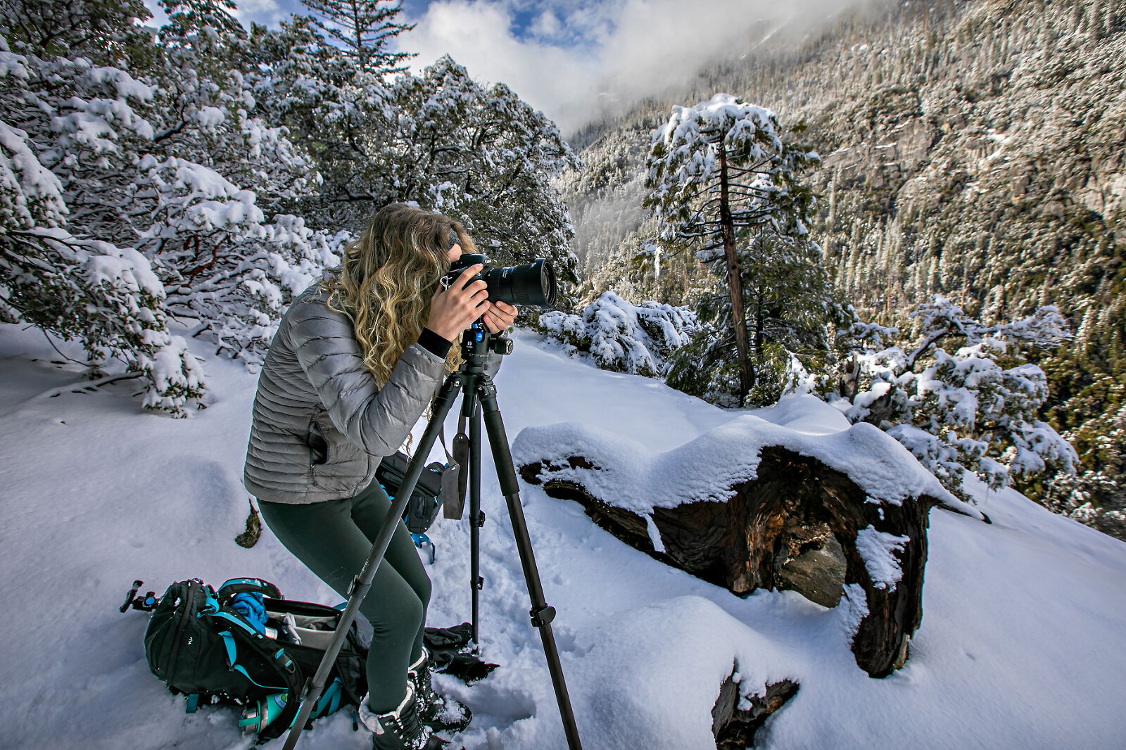 Woman photographing snowy landscape in Yosemite.