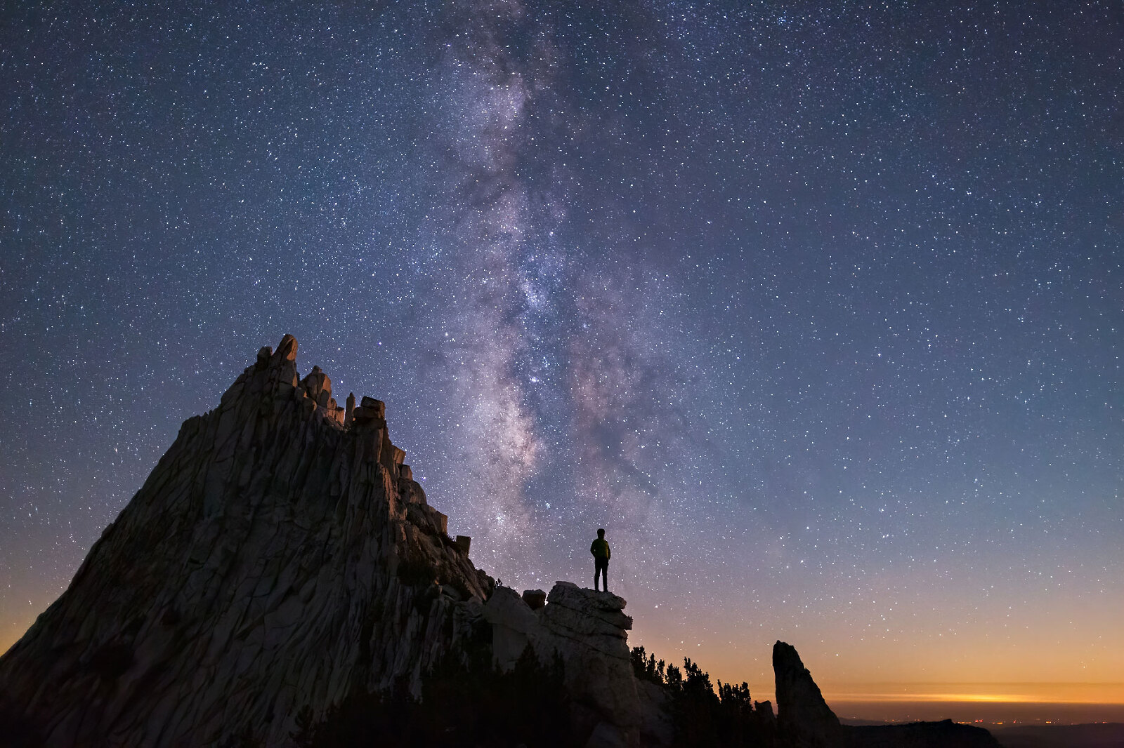 Man standing on mountain under the Milky Way.